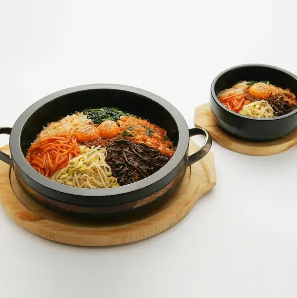 熱した石鍋にご飯、野菜、肉を盛り付けたジャンボ石焼きビビンバ