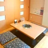 掘りごたつ席のある焼肉店の店内に並ぶ木製テーブルと無煙ロースター